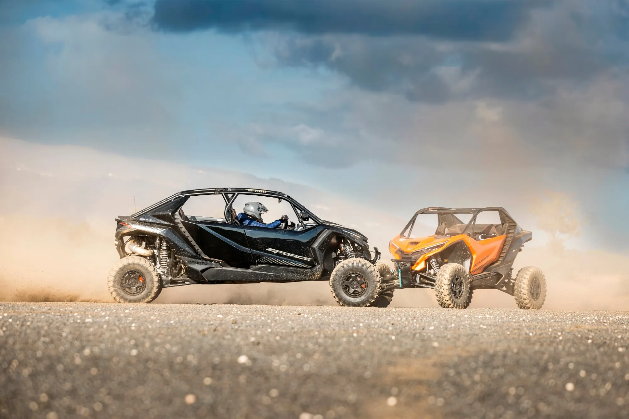 Dos CFMOTO ZFORCE, uno negro y uno naranja, derrapando frente a frente